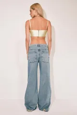 Pantalón de jean celeste de corte wide leg con roturas en las rodillas.