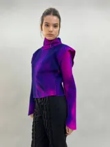 Buzo de lana merino afieltrada con diseño artesanal de efecto degradado en tonos violeta y fucsia. Presenta cuello alto, hombreras marcadas y corte holgado.