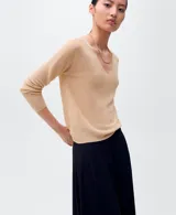 Jersey de punto fino color beige claro, con escote en V y mangas largas.