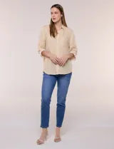 Camisa de corte clásico y silueta relajada con diseño de rayas verticales en blanco y negro. Presenta cuello camisero tradicional, cartera frontal con botones, un bolsillo aplicado en el pecho con rayas horizontales y mangas largas con sistema para arremangar.