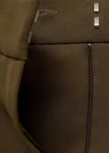 Pantalón wide leg de tiro medio en color verde militar, con diseño de pinzas, trabillas y bolsillos laterales. Cuenta con cierre delantero oculto.