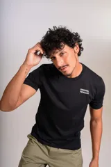 Remera de algodón negra con cuello redondo y mangas cortas. Presenta el logo de la marca estampado en blanco en el lado izquierdo del pecho.