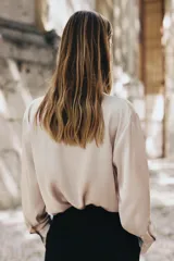 Pantalón blanco de vestir, de tiro alto y corte recto. Presenta bolsillos delanteros de vivo y cierre frontal con cremallera, botón interior y gancho metálico.