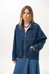 Campera de jean azul de silueta relajada, con cuello clásico, cierre frontal con cremallera metálica y bolsillos laterales.