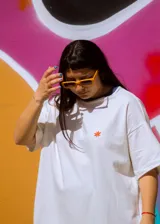 Remerón unisex de algodón color crudo con cuello redondo y estampado en la espalda con la inscripción "DELK BRISHA CLUB" en color naranja.