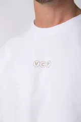 Remera de corte boxy y fit cuadrado, confeccionada en algodón grueso de alta calidad. Presenta un diseño minimalista en el frente con un pequeño logo circular y una estampa de gran tamaño en la espalda con la frase 'Designed in South America, Worldwide Clothes'.