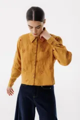 Camisa color mostaza con estampado de cartas y dados, de corte recto, manga larga y cuello camisero.