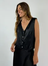 Chaleco negro con escote en V y cierre frontal con botones.