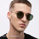 Lentes de sol con montura redonda de metal dorado y cristales polarizados color marrón. Presentan un diseño clásico con puente nasal detallado y patillas finas.