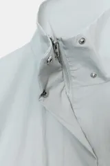 Chaqueta corta de cuello subido con manga larga, cierre frontal con cremallera y botones a presión ocultos. Presenta bolsillos delanteros y puños con pliegues.