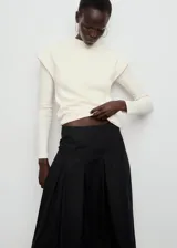 Falda midi evasé de tiro medio color negro, con diseño de tablas y detalle de vivo en el borde inferior. Cuenta con cierre de cremallera lateral.