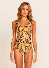 Traje de baño enterizo con estampado de hojas en tonos amarillo, marrón y violeta.