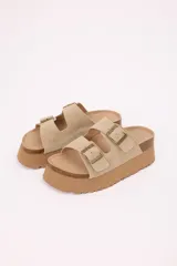 Sandalias planas color beige con plataforma liviana, doble tira en símil gamuza y hebillas metálicas regulables.