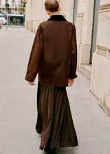 Parka de estilo encerado en color marrón, con diseño recto, cuello camisero de pana en contraste, cierre frontal con cremallera y botones, y múltiples bolsillos de parche con solapa.