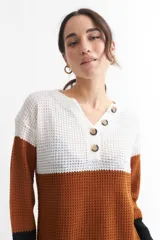 Sweater de tejido de punto con franjas horizontales en color blanco, verde claro y verde oscuro. Tiene cuello en V con botones.