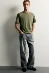 Jeans de denim de algodón en color azul con efecto desgastado, tiro medio y corte recto de ajuste holgado (loose fit). Cuenta con diseño clásico de cinco bolsillos y cierre frontal con cremallera y botón.