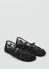 Zapato tipo bailarina de malla negra con bordado de lentejuelas y tira con hebilla.