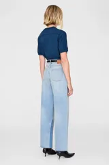 Camiseta blanca de algodón con cuello redondo y mangas cortas con ribete negro. Estampado frontal con la leyenda "ANINE BING PARIS" en letras negras.