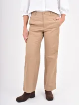 Pantalon de corte recto y tiro alto, confeccionado en gabardina color beige. Presenta cierre frontal con botón y bolsillos laterales.