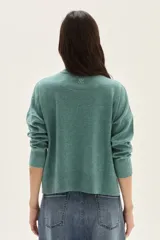 Polera de tejido de punto color azul, con cuello alto, manga larga y puños acanalados.