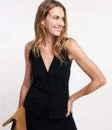Blusa estilo chaleco, confeccionada en ribana negra, con abotonado delantero, sin mangas y con textura acanalada.
