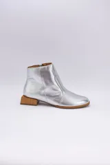 Botín de cuero dorado con punta fina y taco bajo cuadrado de madera.