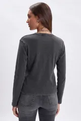 Remera de manga larga confeccionada en tejido rib con efecto lavado, cuello redondo y corte recto.