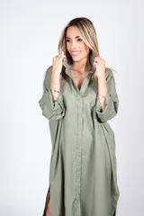 Vestido camisero verde militar, de corte amplio y largo midi, con cuello camisero, abotonadura frontal y mangas largas con puños abotonados.
