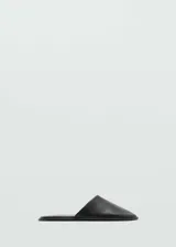 Mules de cuero caprino color negro, con punta triangular y diseño destalonado.