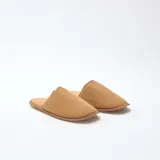 Pantuflas cerradas de terciopelo color marrón camel, con ribetes al tono y suela plana.