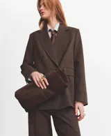 Blazer de corte sastre con diseño de doble botonadura, confeccionado en tejido con patrón de cuadros sutiles. Presenta solapas clásicas, bolsillos con solapa y una estructura entallada que aporta un estilo formal y sofisticado.