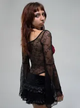 Pollera mini tipo skort de color negro, con diseño de volados de encaje y satén. Cuenta con short integrado y ajuste regular.