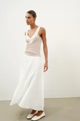 Top de punto canalé en color beige, con escote en pico adornado con una delicada aplicación de encaje blanco y tirantes anchos.