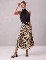 Falda midi de satén con estampado abstracto en tonos negro, beige y dorado. Presenta un corte fluido y cintura elastizada.