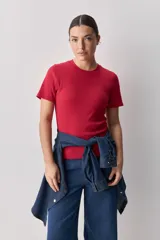 Remera blanca de manga corta y cuello redondo, con calce ajustado al cuerpo y diseño liso y minimalista.
