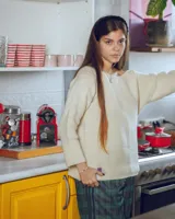 Buzo de lana merino con cuello bote y mangas largas. Presenta un detalle bordado a mano en color azul en la parte inferior.