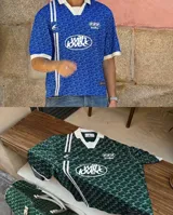 Camiseta tipo polo de Scuffers, color verde con estampado monograma y detalles en blanco en el cuello, los puños y los gráficos frontales de estilo deportivo vintage.