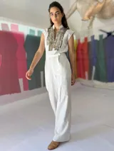 Mono largo azul marino con estampado dorado en la parte superior, cuello mao, sin mangas, con cinturón y bolsillos laterales.