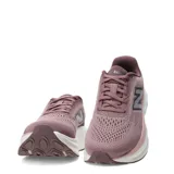 Championes New Balance Kaiha de mujer, color rosado con entresuela blanca y rosada clara, y suela marrón. Presenta el logotipo "N" característico en los laterales.