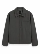 Campera tipo harrington de color gris oscuro, con cuello clásico, cierre frontal completo y bolsillo con cierre en el pecho. Presenta bolsillos laterales y un pequeño aplique de marca en el puño.