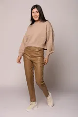 Pantalon chupin de ecocuero negro, de tiro alto con cierre y botón frontal, y bolsillos laterales.