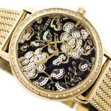 Reloj GUESS modelo Willow con caja redonda dorada de 36mm, bisel con piedras blancas y esfera negra con diseño floral en blanco. Malla metálica dorada y cristal mineral resistente. Resistente al agua hasta 3 ATM.