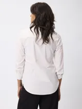 Camisa de manga larga en color negro, con cuello clásico y cierre frontal de botones. Presenta un corte entallado y puños con botones.