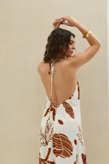 Vestido largo blanco con estampado marrón de temática marina, tirantes finos y escote pronunciado en la espalda.