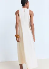 Vestido midi de corte evasé, sin mangas, con cuello caja y cierre posterior de cremallera y botón.