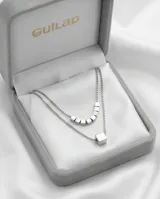 Collar doble de acero con cadenas finas. La cadena superior presenta varios cubos pequeños alineados, mientras que la cadena inferior cuenta con un dije central en forma de cubo.