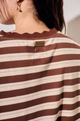 Vestido midi de manga corta con diseño a rayas horizontales en tonos marrones y beige, cuello redondo con detalle ondulado y corte recto.