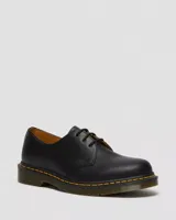 Zapato de estilo oxford Dr. Martens modelo 1461, confeccionado en cuero liso negro. Presenta cierre de cordones, suela de goma con cámara de aire y el característico pespunte amarillo en el borde.