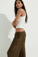 Pantalón de corte wide leg con textura arrugada, cintura elástica y bolsillos laterales.