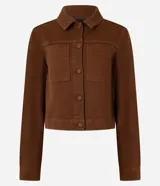 Campera marrón de sarga con textura cotelê, corte regular, cuello inglés, manga larga, abotonada y con bolsillos delanteros.